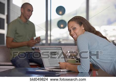 Picture - African American woman next to laptop. Fotosearch