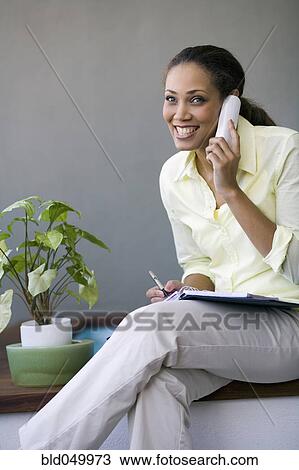 Stock Image - African American woman talking on telephone. Fotosearch