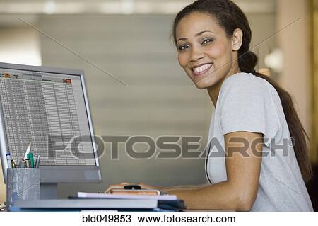 Stock Image - African American woman typing on computer. Fotosearch