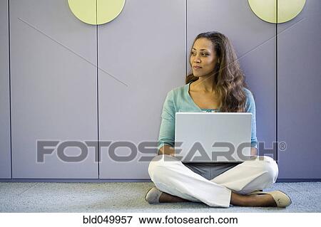 African American woman using laptop on floor View Large Photo Image Stock Photo - African American woman using laptop on floor. Fotosearch