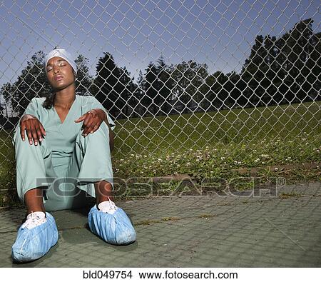 African female nurse sitting against fence View Large Photo Image Picture - African female nurse sitting against fence. Fotosearch
