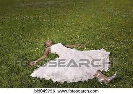 Stock Photography - African woman laying in grass. Fotosearch