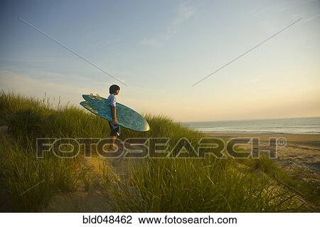 Asian boy holding surfboard at beach View Large Photo Image Stock Image - Asian boy holding surfboard at beach. Fotosearch