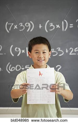 Stock Photography - Asian boy holding up A paper. Fotosearch