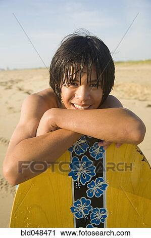 Asian boy leaning on surfboard View Large Photo Image Stock Image - Asian boy leaning on surfboard. Fotosearch