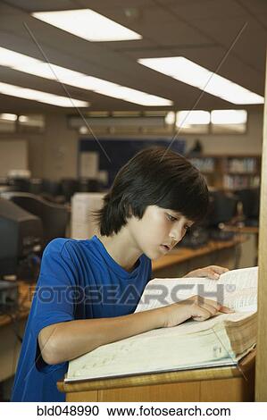 Asian boy reading library dictionary View Large Photo Image Stock Image - Asian boy reading library dictionary. Fotosearch