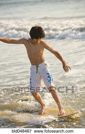 Stock Photo - Asian boy wakeboarding. Fotosearch