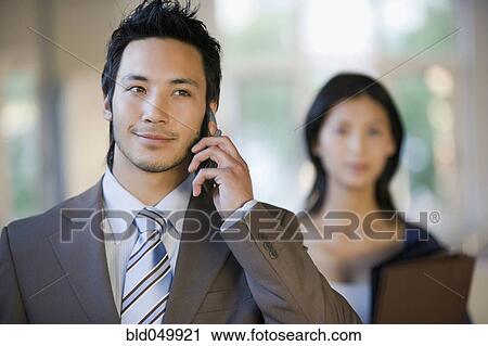 Asian businessman talking on cell phone View Large Photo Image Stock Image - Asian businessman talking on cell phone. Fotosearch