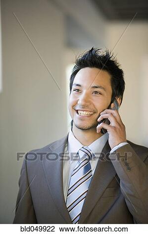 Asian businessman talking on cell phone View Large Photo Image Stock Image - Asian businessman talking on cell phone. Fotosearch