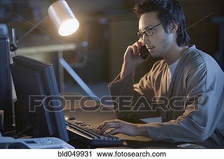 Stock Image - Asian businessman talking on cell phone. Fotosearch