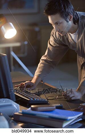Picture - Asian businessman typing on computer. Fotosearch