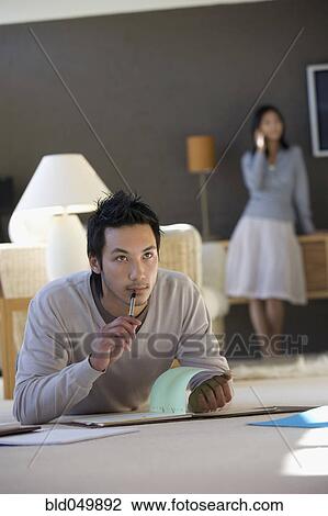 Stock Image - Asian businessman working on floor. Fotosearch