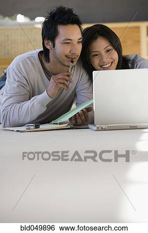 Stock Photograph - Asian businessman working on floor. Fotosearch