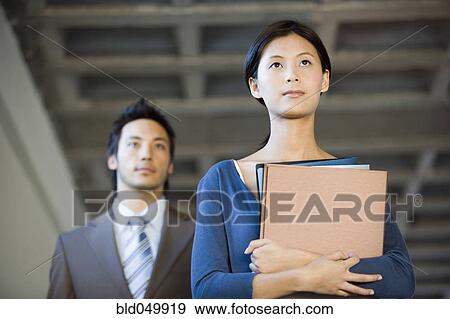 Stock Photo - Asian businesswoman holding folders. Fotosearch