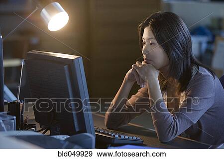 Stock Photo - Asian businesswoman looking at computer. Fotosearch