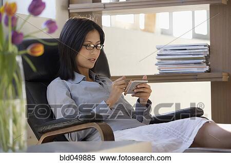 Asian businesswoman looking at electronic organizer View Large Photo Image Stock Photography - Asian businesswoman looking at electronic organizer. Fotosearch