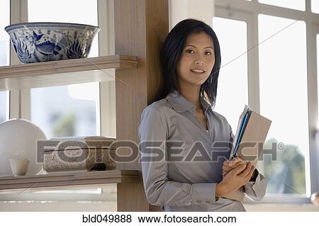 Asian businesswoman looking holding folders View Large Photo Image Stock Photo - Asian businesswoman looking holding folders. Fotosearch