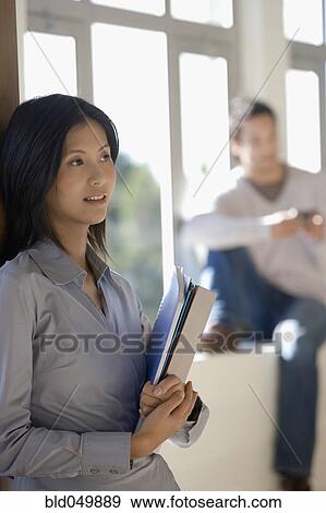 Asian businesswoman looking holding folders View Large Photo Image Stock Photo - Asian businesswoman looking holding folders. Fotosearch