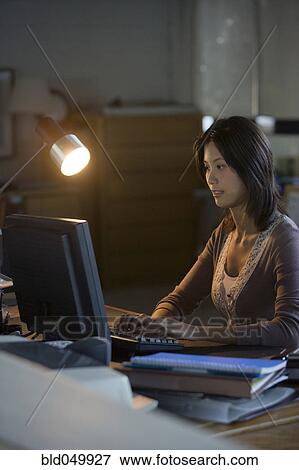 Stock Photo - Asian businesswoman typing on computer. Fotosearch