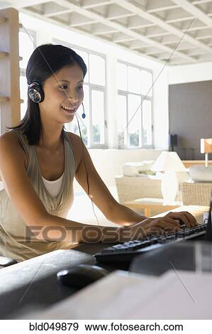 Stock Photo - Asian businesswoman wearing headset. Fotosearch