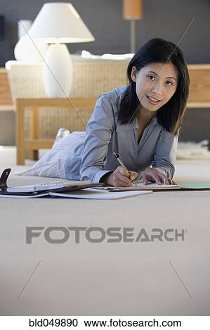 Stock Image - Asian businesswoman working on floor. Fotosearch