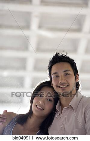 Stock Image - Asian couple hugging. Fotosearch