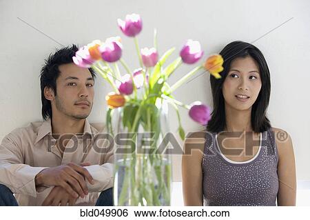 Asian couple looking at flowers in vase View Large Photo Image Stock Photograph - Asian couple looking at flowers in vase. Fotosearch