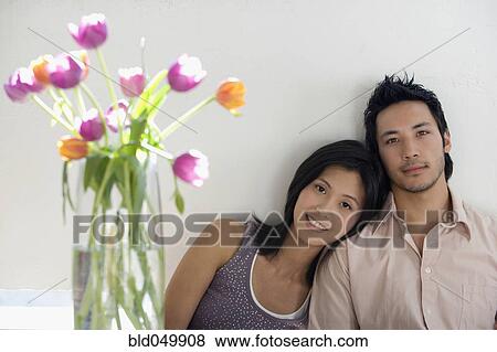 Asian couple next to flowers in vase View Large Photo Image Stock Photo - Asian couple next to flowers in vase. Fotosearch