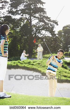 Asian couple playing golf View Large Photo Image Picture - Asian couple playing golf. Fotosearch