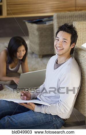 Stock Image - Asian couple working at home. Fotosearch