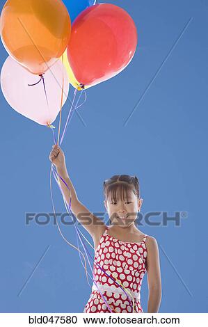 Asian girl holding bunch of balloons View Large Photo Image Stock Image - Asian girl holding bunch of balloons. Fotosearch
