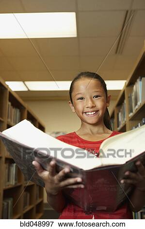 Asian girl holding library dictionary View Large Photo Image Stock Photo - Asian girl holding library dictionary. Fotosearch