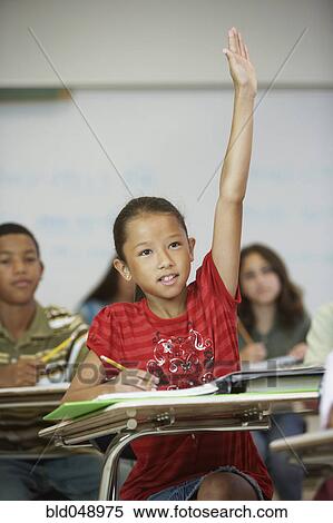Stock Photography - Asian girl raising hand in class. Fotosearch