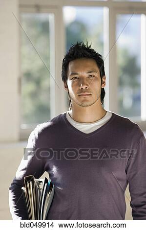 Picture - Asian man carrying binders. Fotosearch