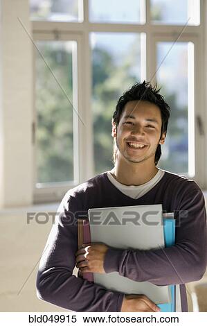 Stock Photography - Asian man holding binders. Fotosearch
