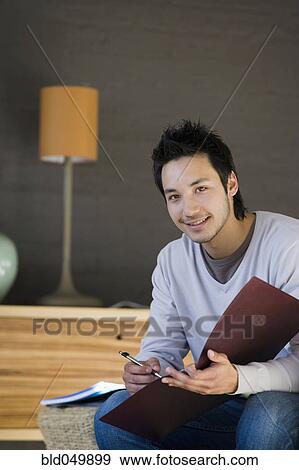 Asian man holding folder View Large Photo Image Stock Photo - Asian man holding folder. Fotosearch