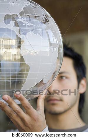 Stock Photo - Asian man holding globe. Fotosearch