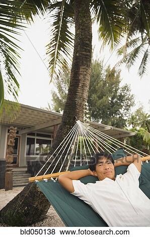 Asian man laying in hammock View Large Photo Image Stock Photo - Asian man laying in hammock. Fotosearch
