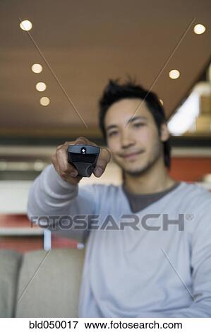 Asian man pointing remote control View Large Photo Image Stock Photo - Asian man pointing remote control. Fotosearch