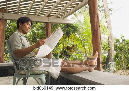 Asian man reading newspaper View Large Photo Image Stock Photo - Asian man reading newspaper. Fotosearch