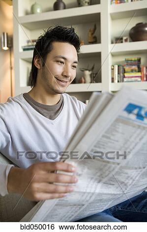 Stock Photograph - Asian man reading newspaper. Fotosearch