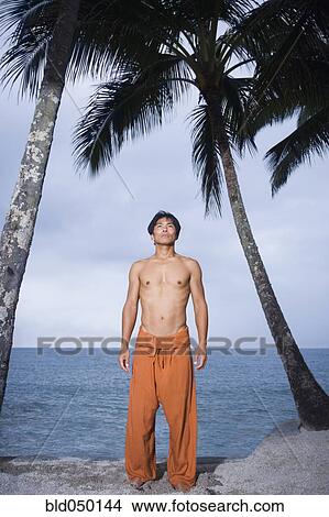Asian man standing on beach View Large Photo Image Picture - Asian man standing on beach. Fotosearch