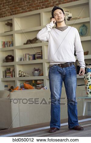 Stock Image - Asian man talking on telephone. Fotosearch