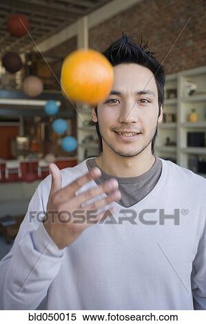 Asian man tossing fruit in air View Large Photo Image Stock Photography - Asian man tossing fruit in air. Fotosearch