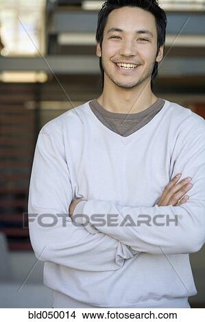 Picture - Asian man with arms crossed. Fotosearch