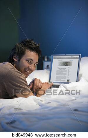 Asian man with laptop View Large Photo Image Stock Image - Asian man with laptop. Fotosearch