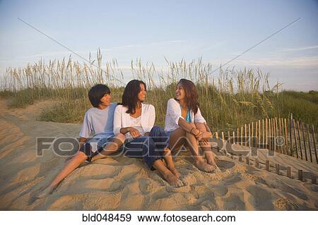 Asian woman and children sitting on beach View Large Photo Image Stock Photo - Asian woman and children sitting on beach. Fotosearch