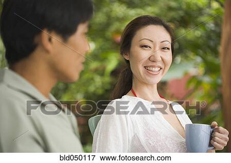 Stock Photo - Asian woman drinking coffee. Fotosearch