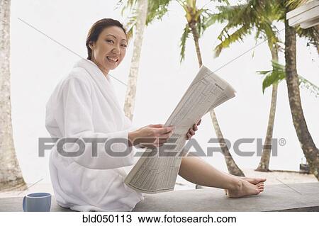 Asian woman in bathrobe reading newspaper View Large Photo Image Stock Image - Asian woman in bathrobe reading newspaper. Fotosearch