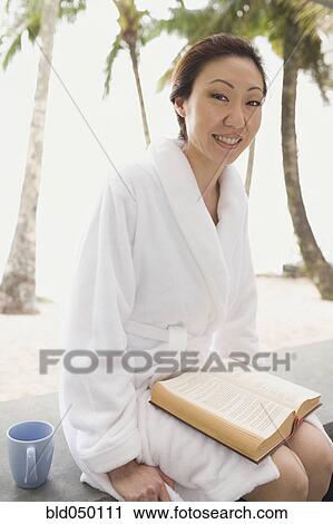 Asian woman in bathrobe with book View Large Photo Image Stock Image - Asian woman in bathrobe with book. Fotosearch